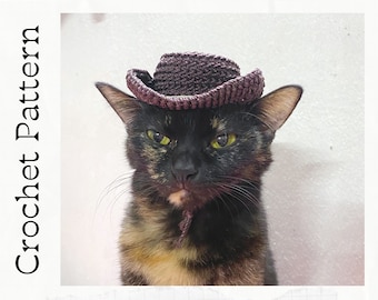 Puede incluir: Un gato atigrado negro y marrón con un sombrero vaquero de ganchillo marrón. Patrón de ganchillo.