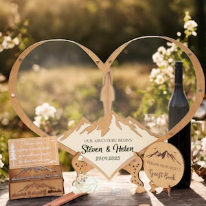 May include: Wooden wedding decor featuring a heart-shaped frame with mountain and couple silhouettes. The text "OUR ADVENTURE BEGINS" and names are displayed. Includes a guest book sign and a wine bottle, all in a natural wood finish.