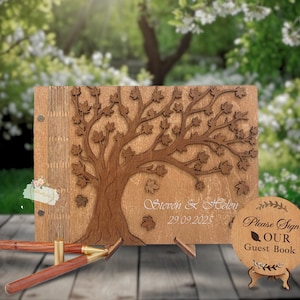 May include: Wooden guest book with a tree design, featuring the names "Steven & Helen" and the date "29.09.2025". Includes a matching wooden sign that reads "Please Sign OUR Guest Book". Also includes two wooden pens.
