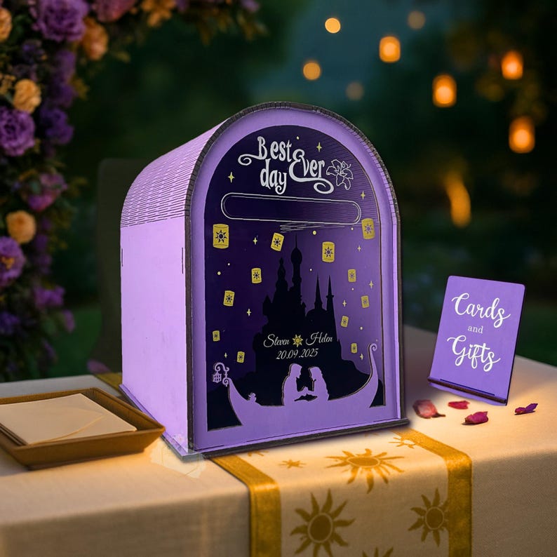 May include: A lavender wooden card box with a decorative design featuring a silhouette of a castle, lanterns, and a boat. The text "Best day ever" is at the top. A small sign reads "Cards and Gifts".