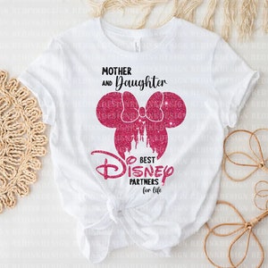 May include: White t-shirt with pink glitter Mickey Mouse ears and a bow. The text "Mother and Daughter Best Disney Partners for Life" is printed on the shirt.