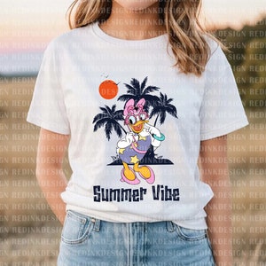 May include: White t-shirt with a cartoon image of a duck wearing sunglasses and a pink bow. The duck is standing in front of palm trees and a red sun. The text "Summer Vibe" is printed below the image.