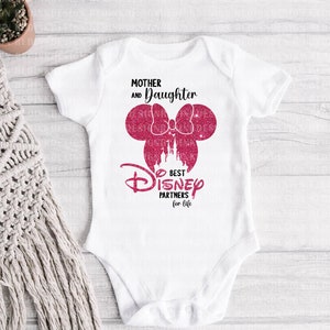 May include: White baby onesie with pink glitter Mickey Mouse ears and a castle graphic. The text reads "Mother and Daughter Best Disney Partners for Life."