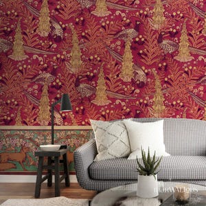 Può includere: Una stanza con una carta da parati rosso scuro con motivi botanici e di uccelli dorati e beige. Un divano con rivestimento fantasia e cuscini bianchi è posizionato davanti alla carta da parati. Un tavolino e una lampada sono in primo piano.
