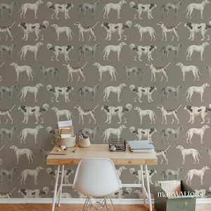 Può includere: Carta da parati con un motivo ripetuto di illustrazioni stilizzate di cani in tonalità di grigio, bianco e marrone. I cani sono raffigurati in varie pose su uno sfondo grigio tenue. Una scrivania in legno, una sedia bianca e forniture per ufficio in primo piano.