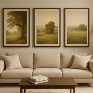 Peut inclure: Trois impressions d'art encadrées avec des images sépia d'arbres et de champs sont accrochées au-dessus d'un canapé beige. Une table basse marron foncé avec des livres est devant le canapé. La pièce a une palette de couleurs neutres.