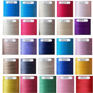 May include: A grid of forty-five cylindrical spools of sewing thread in various colors, each labeled with a white rectangular tag displaying a unique four-digit identification number ranging from 1854 to 3272, arranged in nine rows and five columns.