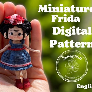 May include: A crochet doll pattern for a miniature Frida Kahlo doll. The doll is wearing a blue dress with red and white trim and a flower crown. The pattern is available in English. The image includes the text "Miniature Frida Digital Pattern" and "Spicaartdoll special for you".