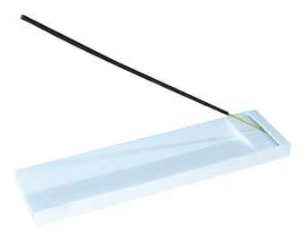 May include: White ceramic incense holder with a black incense stick resting on it.