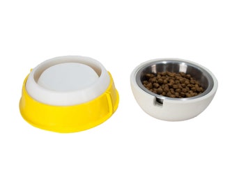 Op de afbeelding: Twee voerbakken, een gele en een witte. De gele bak heeft een witte binnenring. De witte bak heeft een binnenbak van roestvrij staal met bruin dierenvoer.