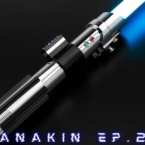 May include: A silver and black lightsaber with a bright blue blade, angled across a black surface. The hilt features buttons and a control panel. The text "ANAKIN EP.2" is at the bottom. The Antromx Sabers logo is in the upper left corner.