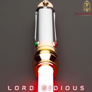 May include: A gold and silver lightsaber with a red blade, the words "LORD SIDIOUS" are displayed at the bottom. The lightsaber has green and red buttons. The top of the lightsaber has a gold design.