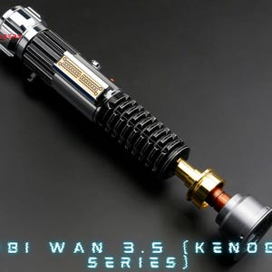May include: A silver and black lightsaber with a gold connector and a grey end cap. The lightsaber is disassembled and the parts are laid out on a grey surface. The text "OBI WAN 3.5 (KENOBI SERIES)" is printed in blue on the surface.