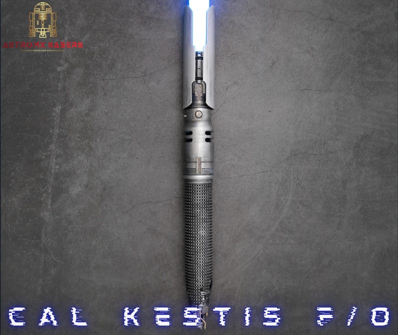 K&ouml;nnte beinhalten: Ein silbernes Lichtschwert mit einer blauen Klinge. Das Lichtschwert hat einen strukturierten Griff und einen schwarzen Knopf an der Seite. Der Text "CAL KESTIS 5/0" ist am unteren Rand des Bildes sichtbar.