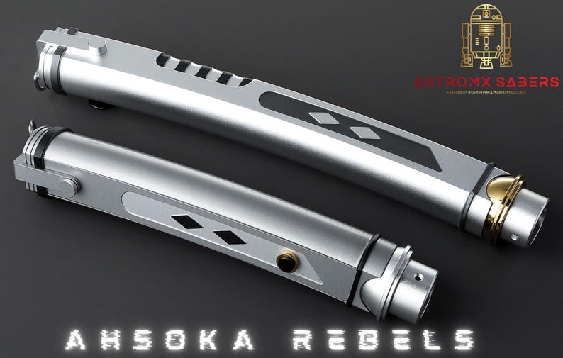 May include: Two silver lightsabers with black and gold accents, featuring a diamond pattern and the text "AHSOKA REBELS." The lightsabers have a sleek, metallic design, with a gold-colored end cap. The image also includes a gold logo.
