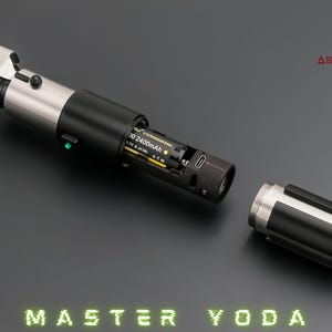 May include: A silver and black lightsaber, partially disassembled, with the text "MASTER YODA" in green neon. The hilt is open, showing the battery compartment. The Astro MX Sabers logo is in the top right corner.