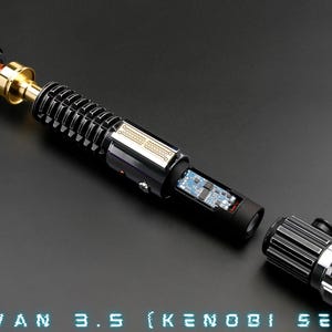 May include: A disassembled lightsaber with a black and silver handle, a gold connector, and a circuit board visible inside. The lightsaber is labelled "OBI WAN 3.5 (KENOBI SERIES)".