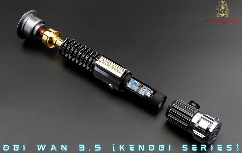 May include: A disassembled lightsaber with a black and silver handle, a gold connector, and a circuit board visible inside. The lightsaber is labelled "OBI WAN 3.5 (KENOBI SERIES)".