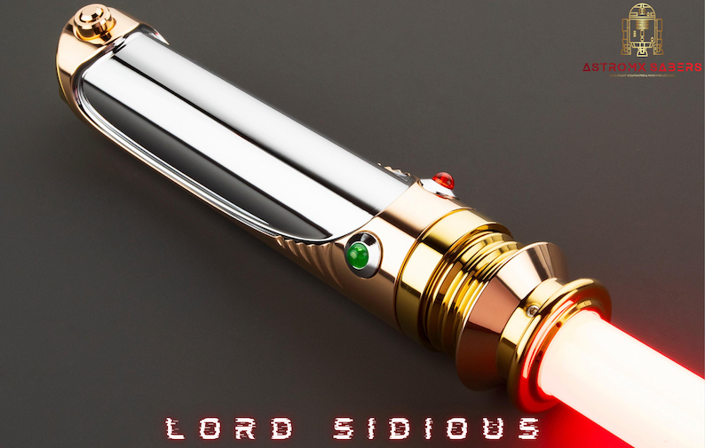 May include: A lightsaber with a silver and gold hilt, featuring red and green buttons. The blade emits a bright red glow. The text "LORD SIDIOUS" is displayed in red at the bottom. The logo of a golden droid is in the upper right corner.