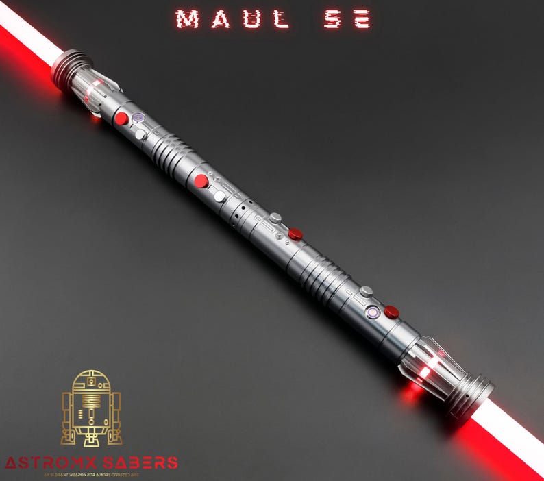 Op de afbeelding: Een zilveren lichtzwaard met een rood lemmet, met rode en zilveren knoppen en accenten. De tekst "MAUL SE" wordt bovenaan weergegeven en het Astro Sabers-logo staat onderaan. Het lichtzwaard staat schuin tegen een donkergrijze achtergrond.