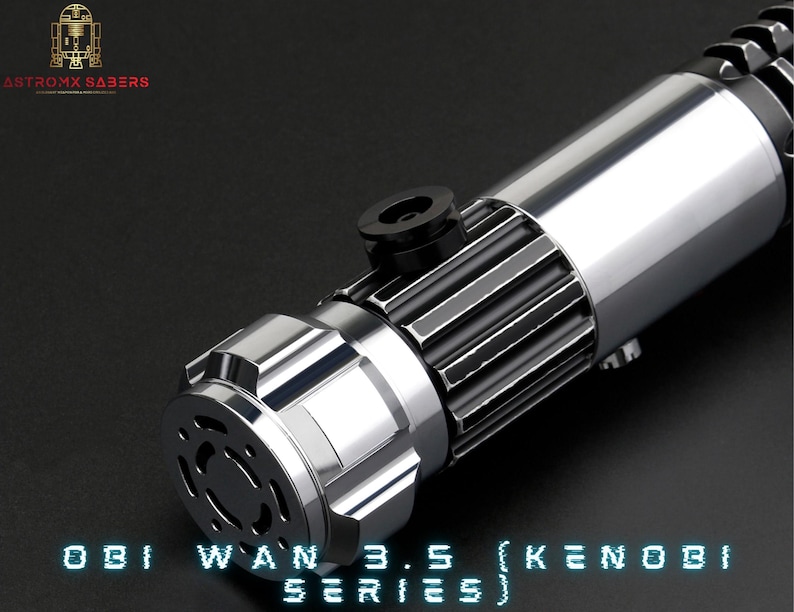 May include: A silver lightsaber with a black grip and a silver emitter. The lightsaber is labelled "Obi Wan 3.5 (Kenobi Series)".
