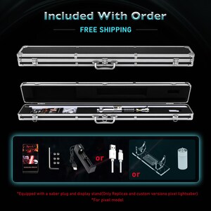 May include: A silver and black lightsaber in an open black case with silver trim. The case contains the lightsaber, a charging cable, and other accessories. Additional accessories include a charging base, a display stand, and a USB cable.