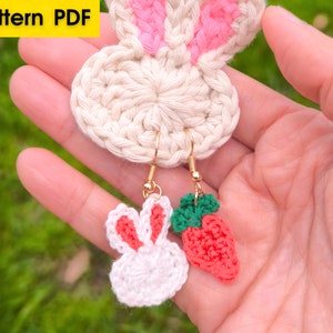 May include: Crocheted bunny and strawberry earrings. The earrings are made of white, pink, red, and green yarn. The bunny earrings have pink ears and the strawberry earrings have green leaves.