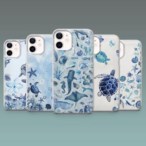 Puede incluir: Cinco fundas transparentes para teléfono con diseños de vida marina. Cada funda presenta un tema acuático diferente, incluyendo tortugas, estrellas de mar y varias criaturas marinas en tonos azules y blancos. Las fundas están dispuestas en fila.