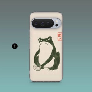 Op de afbeelding: Telefoonhoesje met een illustratie van een groene kikker die een kom vasthoudt, met Japanse tekst in een rood vierkant. De kikker heeft een boze uitdrukking. De hoes is gebroken wit met een transparante rand.