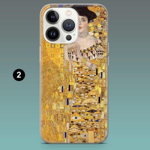 May include: A phone case featuring a portrait by Gustav Klimt. The artwork depicts a woman in a gold and yellow dress with intricate patterns. The case has a clear border and the number "2" is visible on the lower left.