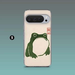 Op de afbeelding: Een telefoonhoesje met een groene kikkerillustratie, witte buik en grote ogen. Het ontwerp doet denken aan Japanse houtsneden. Een rode stempel staat in de rechterbovenhoek. De hoes zit op een lichtbeige achtergrond.