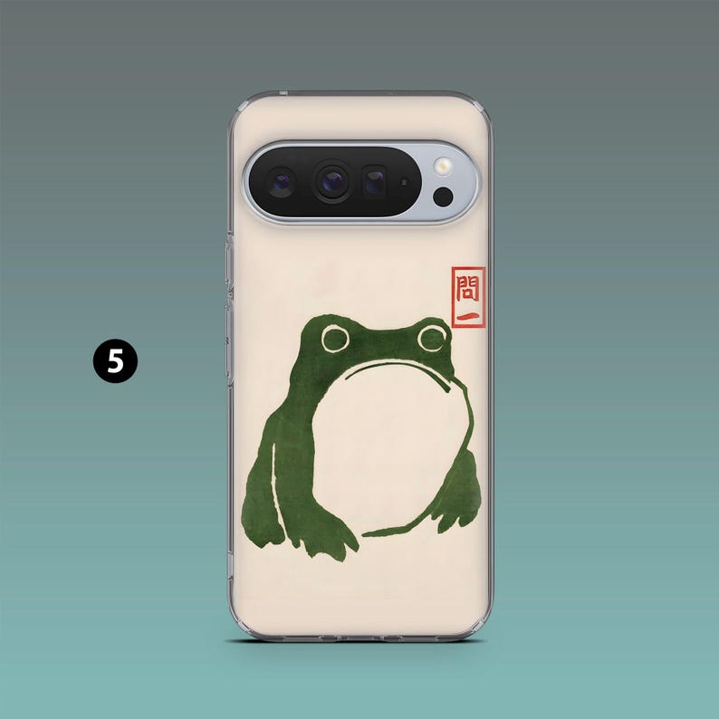 Op de afbeelding: Een telefoonhoesje met een groene kikkerillustratie, witte buik en grote ogen. Het ontwerp doet denken aan Japanse houtsneden. Een rode stempel staat in de rechterbovenhoek. De hoes zit op een lichtbeige achtergrond.