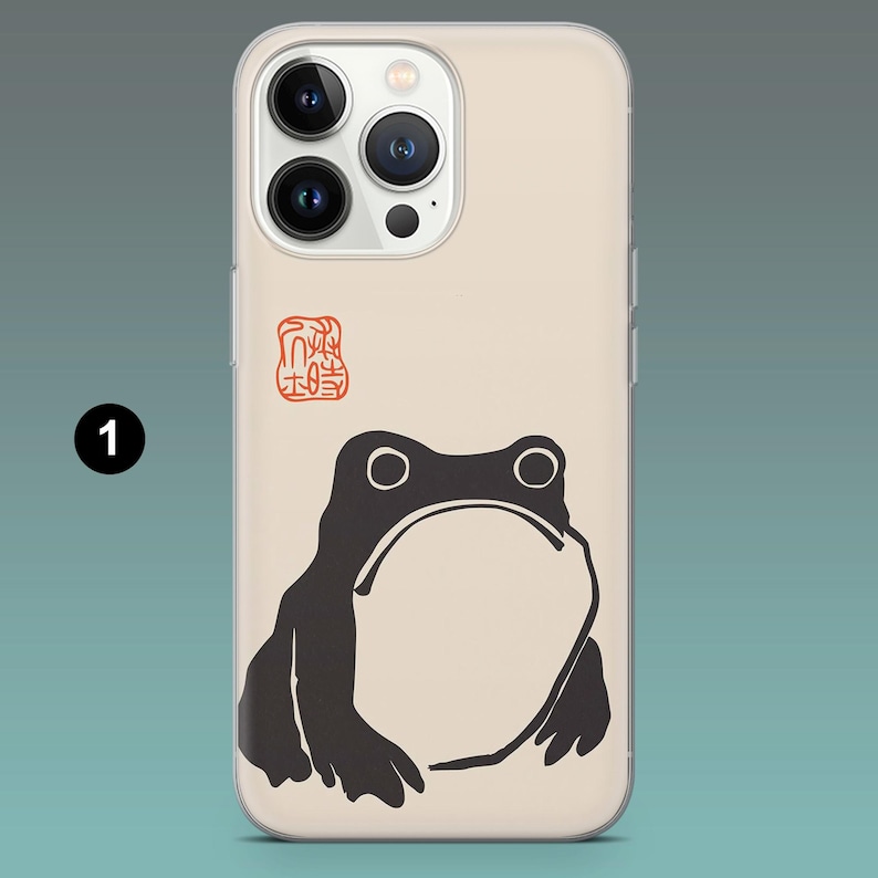 Pode incluir: Capa de telem&oacute;vel com uma ilustra&ccedil;&atilde;o de r&atilde; preta, barriga branca e olhos grandes. O design inclui um selo vermelho sobre um fundo bege. Desenhado para um smartphone.