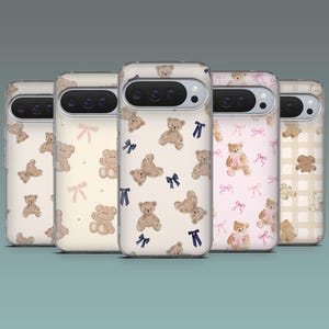 May include: A collection of phone cases with various patterns featuring teddy bears and bows. The cases have a clear background with different color schemes, including beige, pink, and a checkered pattern. The teddy bears are in a watercolor style.