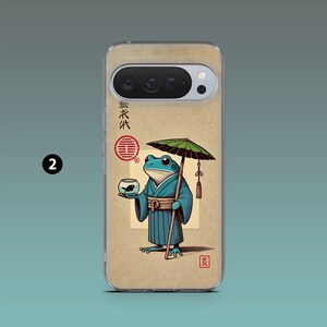 Op de afbeelding: Transparante telefoonhoes met een cartoonkikker in een blauwe kimono die een parasol en een kom met een vis vasthoudt. De achtergrond is beige met Japanse tekst en een rood zegel. De hoes heeft een camera-uitsparing.
