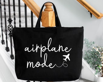 May include: Black canvas tote bag with white text that says "airplane mode" and a small airplane graphic.