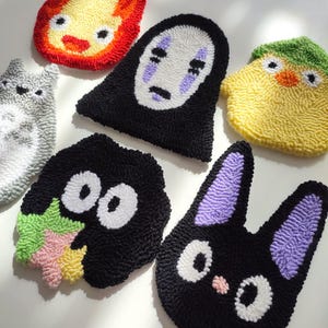 May include: Six colorful felt character patches featuring popular characters from the Studio Ghibli animated films. The characters include No Face, Totoro, Jiji, Calcifer, and Kiki.