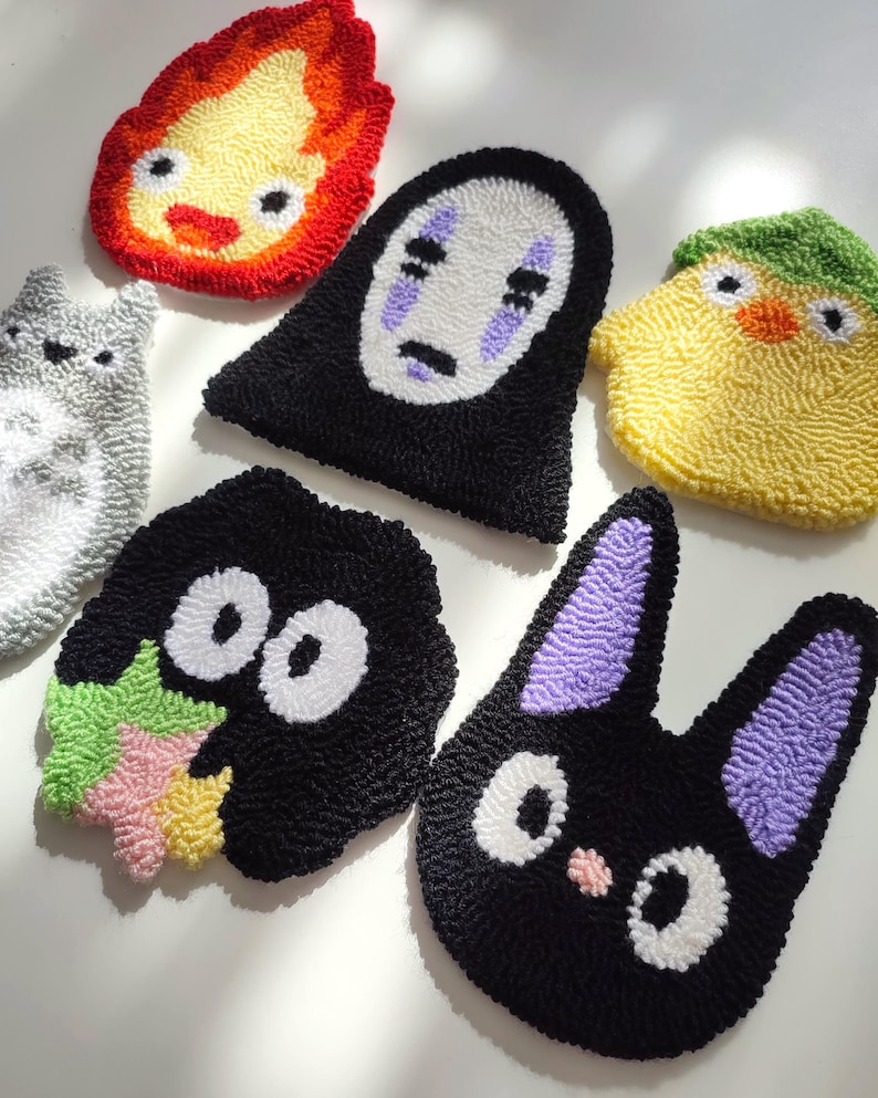 May include: Six colorful felt character patches featuring popular characters from the Studio Ghibli animated films. The characters include No Face, Totoro, Jiji, Calcifer, and Kiki.