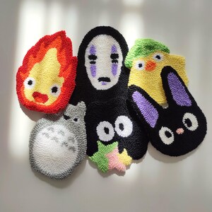 May include: Five colorful, hand-stitched felt characters from the popular animated film Studio Ghibli. The characters include No Face, Totoro, Jiji, Calcifer, and a yellow chick.