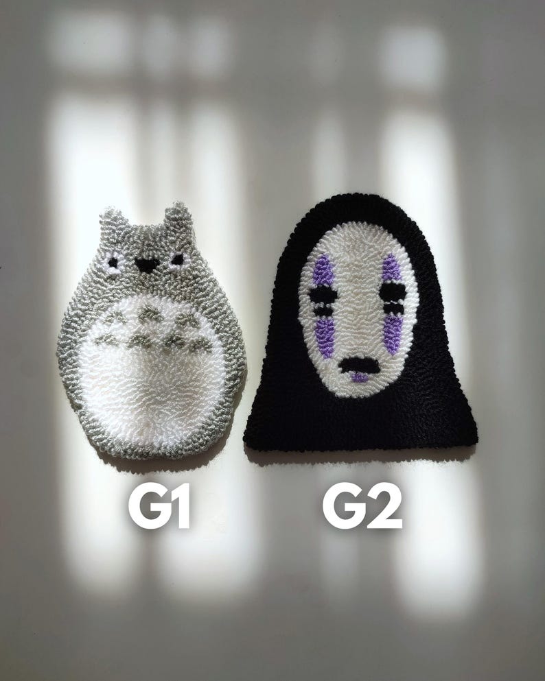 May include: Two handmade plush wall hangings, one is a white and gray Totoro character and the other is a black No Face character from the movie Spirited Away. The hangings are labeled G1 and G2.