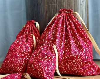 Stoffgeschenkverpackung ohne Abfall, wiederverwendbarer Beutel mit Kordelzug, Weihnachtsmotive auf rotem Hintergrund, Aufbewahrungs- und Reisetasche für Weihnachtsgeschenke