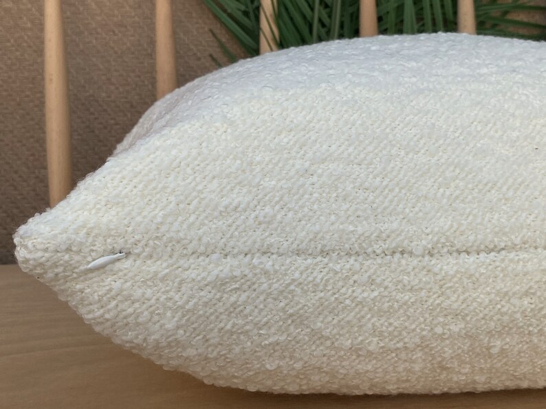 May include: A white, fluffy pillow with a textured surface. The pillow is made of a soft, comfortable material and has a subtle sheen.