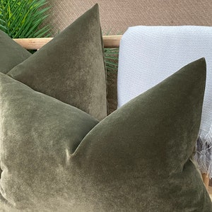 May include: Two green velvet throw cushions with a textured surface.