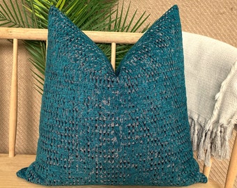 May include: Teal blue cushion with a textured woven pattern. The cushion is sitting on a wooden bench.