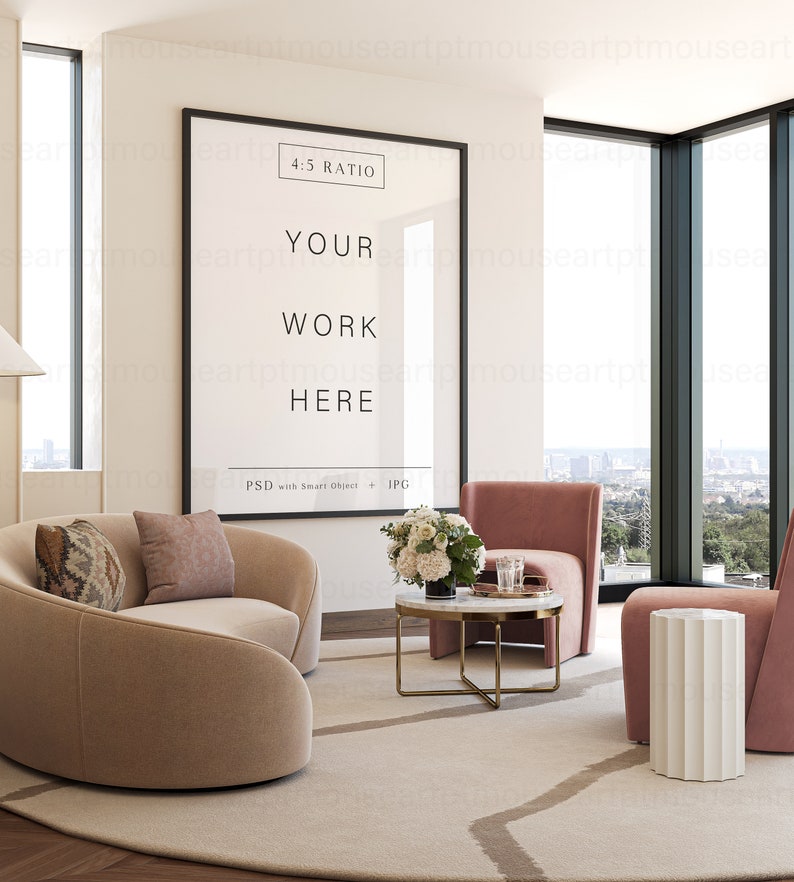 May include: A modern living room interior with a large framed poster that says "4:5 RATIO YOUR WORK HERE PSD with Smart Object + JPG". The poster is hanging on a white wall. There is a beige curved sofa with two pillows, a pink armchair, a white side table, and a coffee table with a marble top and gold legs. There are flowers in a vase on the coffee table.