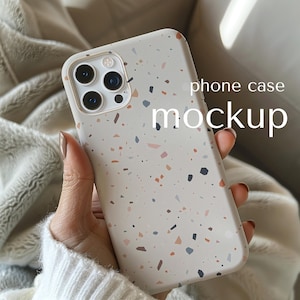 Puede incluir: Una maqueta de funda de teléfono con un diseño moteado en beige, azul, rosa y naranja. La funda tiene un recorte para la cámara y las palabras "phone case mockup" están impresas en la funda.