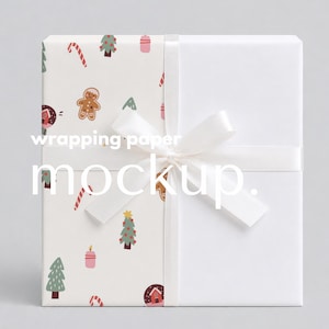 May include: A square gift box wrapped in paper featuring a pattern of gingerbread people, Christmas trees, candy canes, and candles, with a solid white section on the right side, tied with a white satin ribbon and the text wrapping paper mockup.