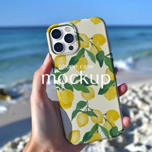 Pode incluir: Uma capa de telemóvel com um padrão de limão. A capa tem um fundo creme com limões amarelos e folhas verdes. As palavras "phone case mockup" estão impressas na capa.