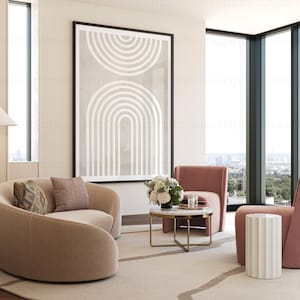 May include: A living room with a curved beige sofa, two pink armchairs, a white side table, a coffee table with a white marble top and gold legs, and a framed abstract print with white lines on a beige background.