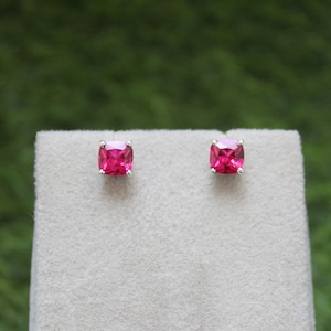 Könnte beinhalten: Ein Paar silberne Ohrstecker mit quadratischen rosafarbenen Edelsteinen.